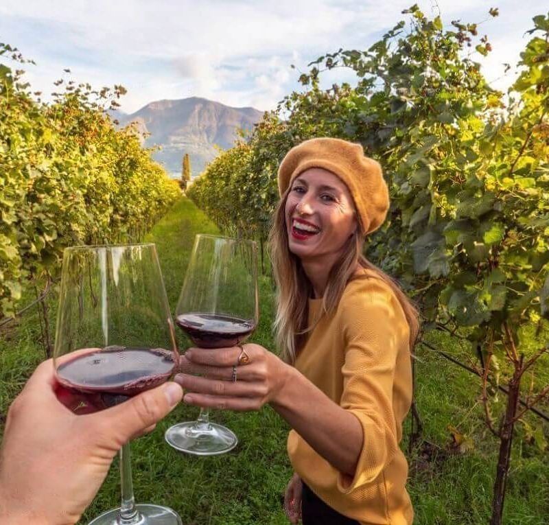 A woman cheering a wine glass on a Yarra valley wine tour