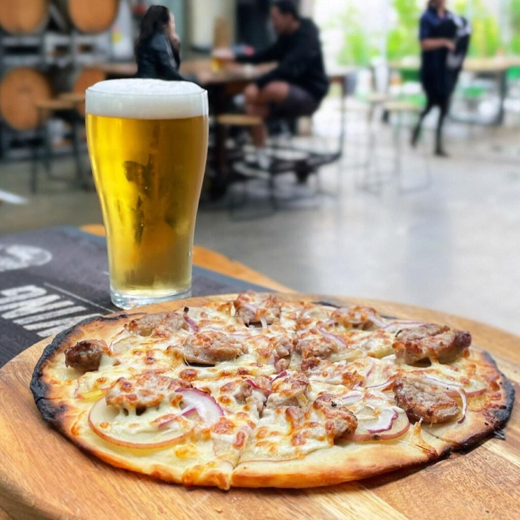 Pizza and beer on table at Watts River Brewing
